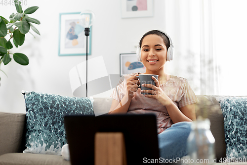 Image of woman with tablet pc drinking coffee at home