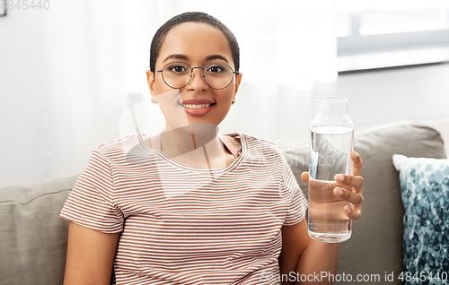 Image of african american woman with water in glass bottle