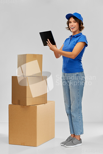 Image of delivery girl with parcel boxes and tablet pc