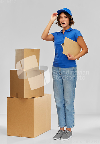 Image of happy delivery girl with boxes and clipboard