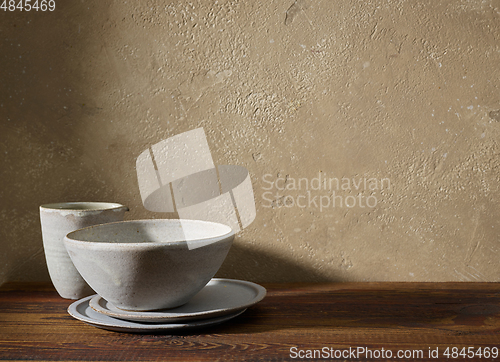 Image of ceramic tableware on wooden shelf