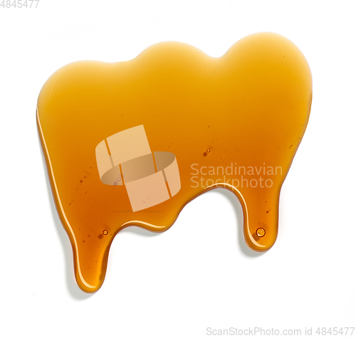Image of flowing sugar syrup on white background