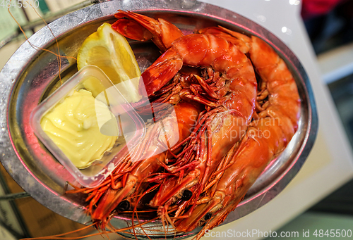 Image of Jumbo shrimps with lemon and sauce on metal plate 
