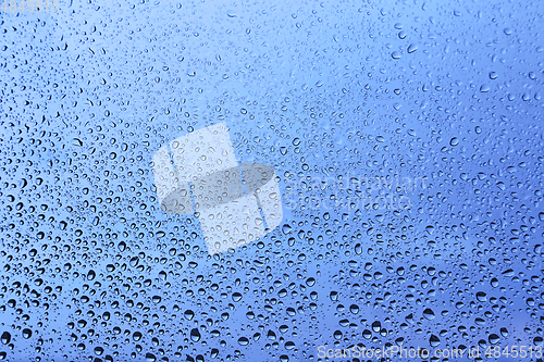 Image of Water drops on glass, blue natural background