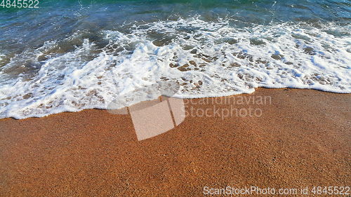 Image of Sea water with white foam in the coastal sand
