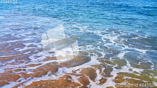 Image of Sea water with white foam on the coastal sand