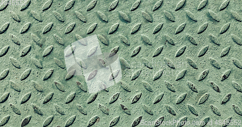 Image of Old metal diamond plate covered with green paint