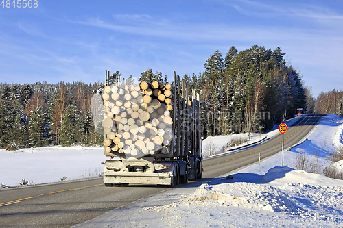 Image of Logging Truck Transports Load of Logs in Winter