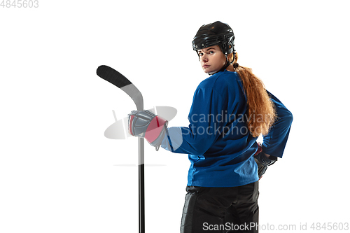 Image of Young female hockey player with the stick on ice court and white background