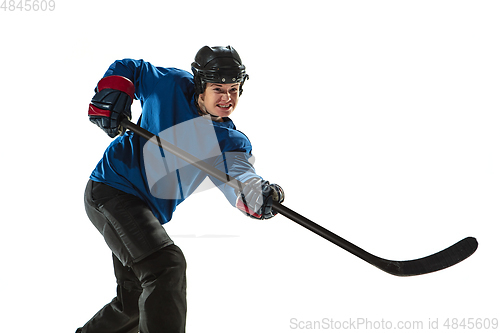 Image of Young female hockey player with the stick on ice court and white background