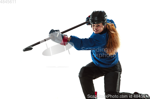 Image of Young female hockey player with the stick on ice court and white background