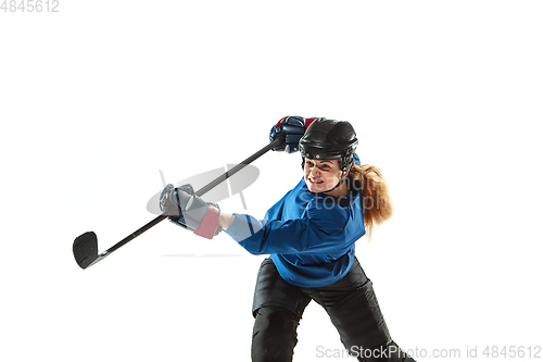 Image of Young female hockey player with the stick on ice court and white background