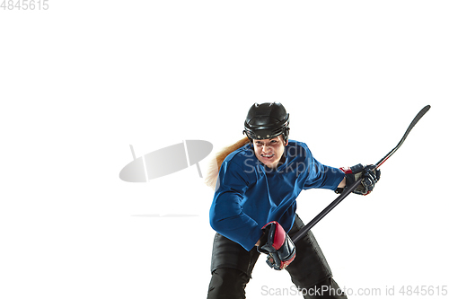 Image of Young female hockey player with the stick on ice court and white background