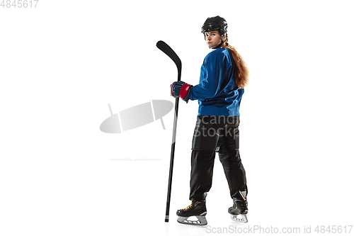 Image of Young female hockey player with the stick on ice court and white background