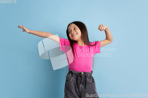 Image of Caucasian little girl\'s portrait on blue studio background