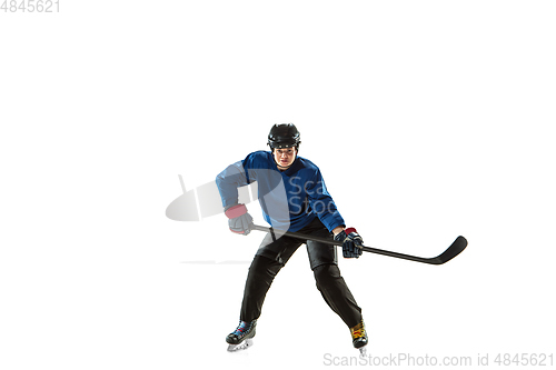 Image of Young female hockey player with the stick on ice court and white background