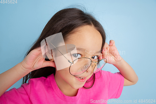 Image of Caucasian little girl\'s portrait on blue studio background