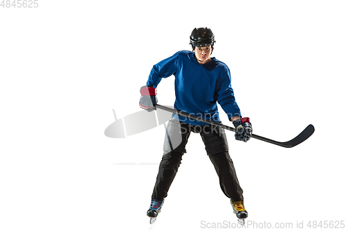 Image of Young female hockey player with the stick on ice court and white background