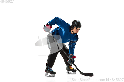 Image of Young female hockey player with the stick on ice court and white background