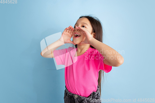 Image of Caucasian little girl\'s portrait on blue studio background