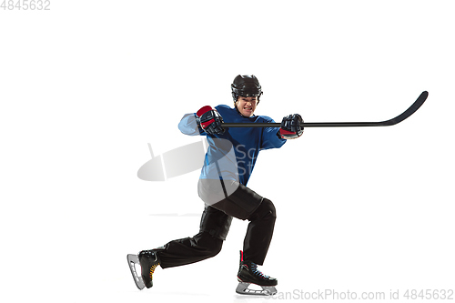 Image of Young female hockey player with the stick on ice court and white background