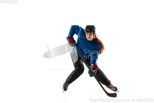 Image of Young female hockey player with the stick on ice court and white background