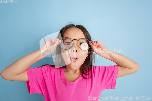 Image of Caucasian little girl\'s portrait on blue studio background