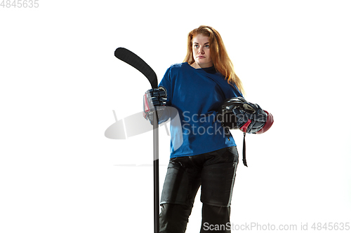 Image of Young female hockey player with the stick on ice court and white background