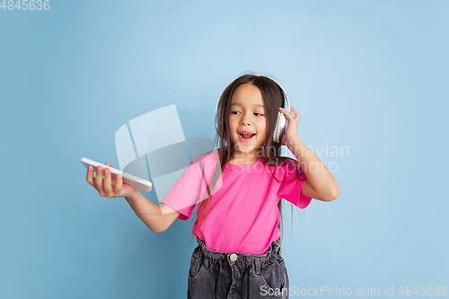 Image of Caucasian little girl\'s portrait on blue studio background