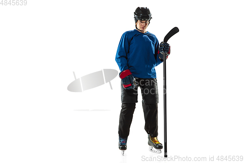 Image of Young female hockey player with the stick on ice court and white background