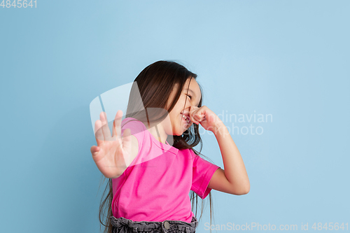 Image of Caucasian little girl\'s portrait on blue studio background