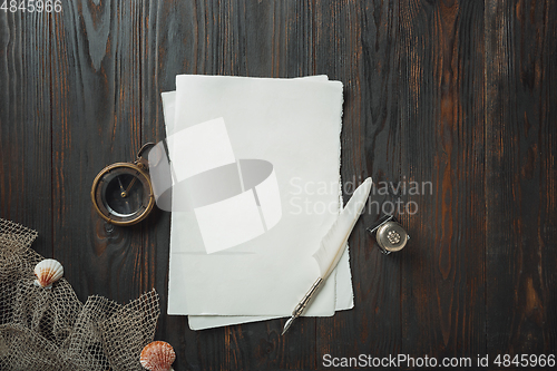 Image of Old fashioned flat lay with letters writing accessories on dark wooden background