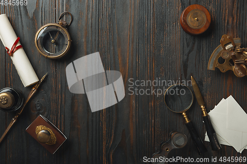 Image of Old fashioned flat lay with letters writing accessories on dark wooden background