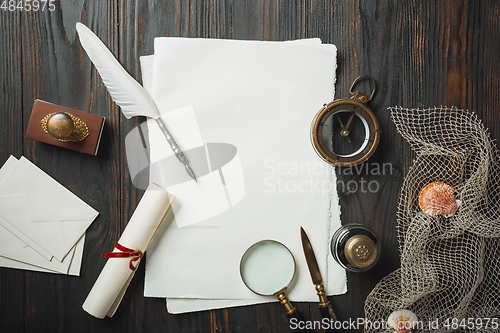 Image of Old fashioned flat lay with letters writing accessories on dark wooden background