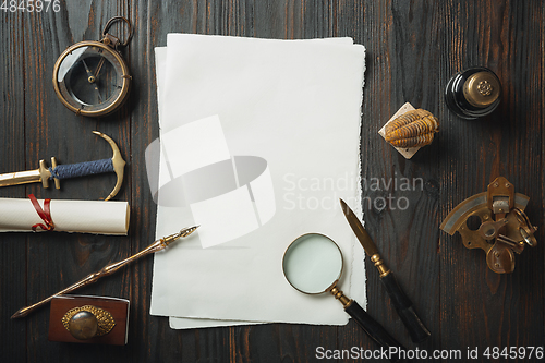 Image of Old fashioned flat lay with letters writing accessories on dark wooden background