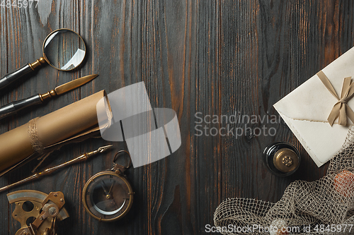 Image of Old fashioned flat lay with letters writing accessories on dark wooden background