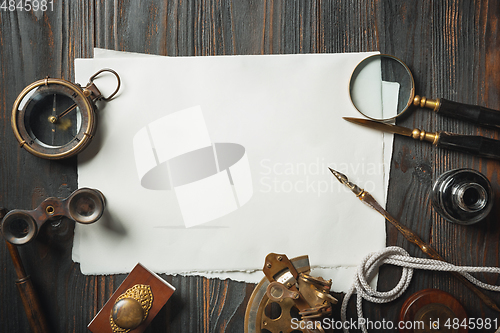 Image of Old fashioned flat lay with letters writing accessories on dark wooden background