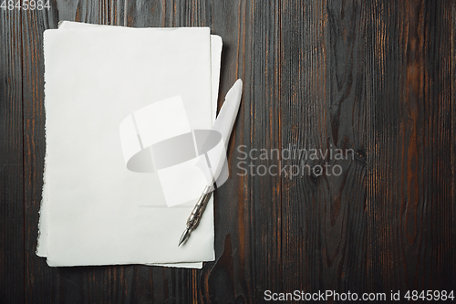 Image of Old fashioned flat lay with letters writing accessories on dark wooden background