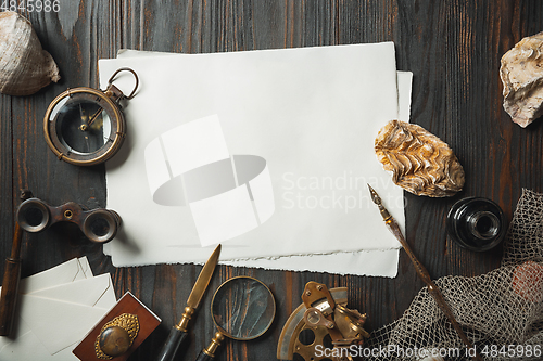 Image of Old fashioned flat lay with letters writing accessories on dark wooden background