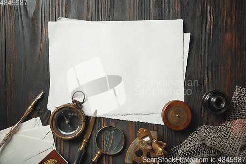 Image of Old fashioned flat lay with letters writing accessories on dark wooden background