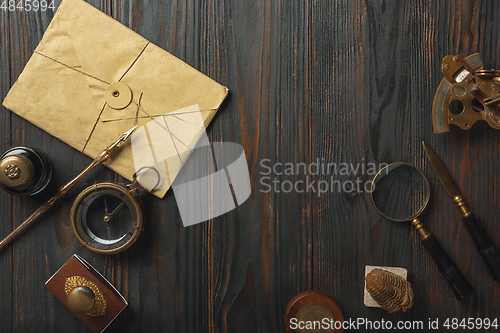 Image of Old fashioned flat lay with letters writing accessories on dark wooden background