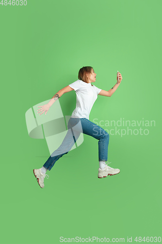 Image of Caucasian young woman\'s portrait on green studio background