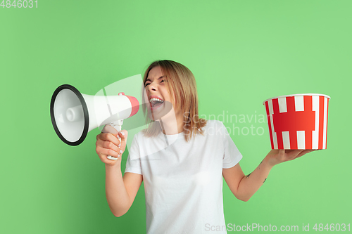 Image of Caucasian young woman\'s portrait on green studio background