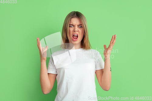 Image of Caucasian young woman\'s portrait on green studio background