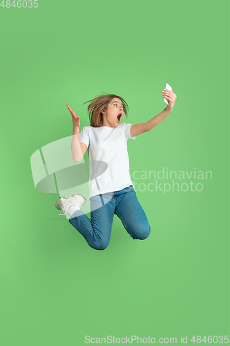Image of Caucasian young woman\'s portrait on green studio background