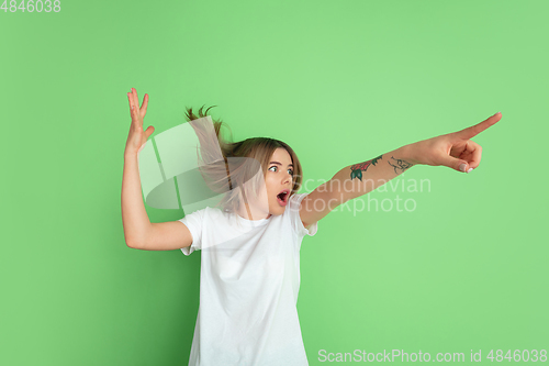 Image of Caucasian young woman\'s portrait on green studio background