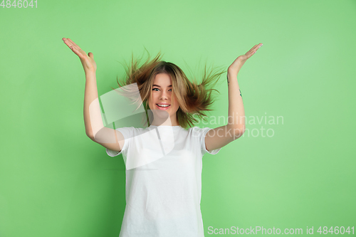 Image of Caucasian young woman\'s portrait on green studio background