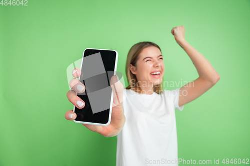 Image of Caucasian young woman\'s portrait on green studio background