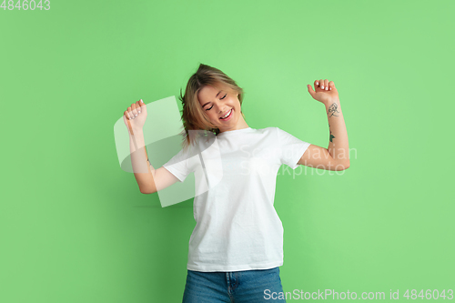 Image of Caucasian young woman\'s portrait on green studio background