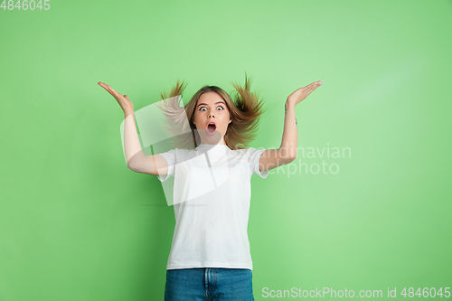 Image of Caucasian young woman\'s portrait on green studio background